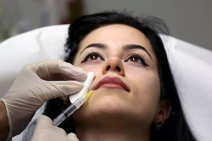 Una mujer se somete a una operación de aumento de labios.