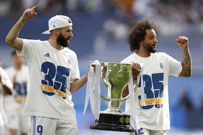 Los jugadores del Real Madrid Karim Benzemá y Marcelo Vieira celebran el título de Liga, al término del partido de Liga en Primera División ante el RCD Espanyol que han disputado este sábado en el estadio Santiago Bernabéu, en Madrid.
