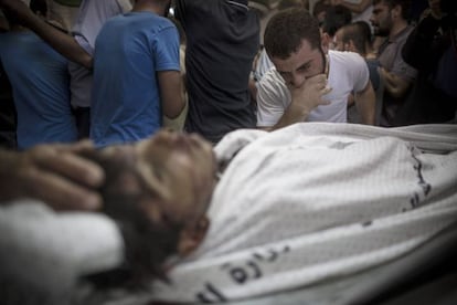 Un hombre llora junto al cadáver de su hermano, el 16 de julio.