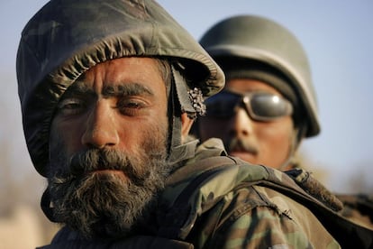 Un soldado del Ejército Nacional Afgano, con una flor marchita en la oreja, patrulla en la provincia de Panjawaii, Kandahar, al sur del país, el 13 de noviembre de 2007.