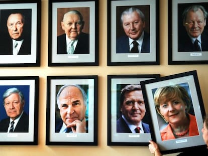 Uma mulher pendura um retrato de Merkel cinco anos atrás.