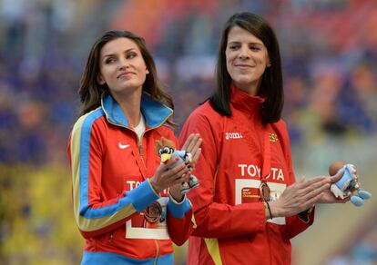 La atleta rusa Anna Chicherova (i) y Ruth Beitia (d), comparten la medalla de bronce tras conseguir la misma puntuación, durante la ceremonia de entrega de medallas del Campeonato Mundial de Atletismo en Moscú de 2013.