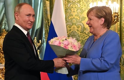 El presidente ruso, Vladimir Putin, recibe a la canciller alemana, Angela Merkel, con un ramo de flores durante su encuentro en el Kremlin, en Moscú.