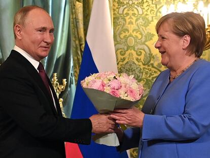 El presidente ruso, Vladimir Putin, recibe a la canciller alemana, Angela Merkel, con un ramo de flores durante su encuentro en el Kremlin, en Moscú.