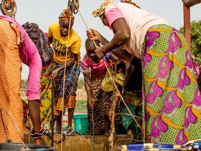 Un grupo de mujeres extrae agua de un pozo del jard&iacute;n de Kolonia, en Mal&iacute;.