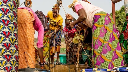 Un grupo de mujeres extrae agua de un pozo del jard&iacute;n de Kolonia, en Mal&iacute;.