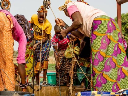 Un grupo de mujeres extrae agua de un pozo del jard&iacute;n de Kolonia, en Mal&iacute;.