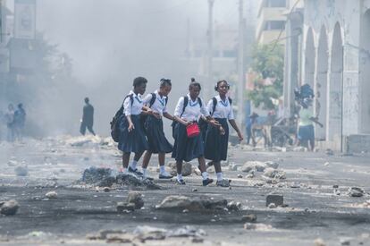 Varias niñas en uniforme escolar caminan por una calle durante una manifestación, en Puerto Príncipe (Haití).