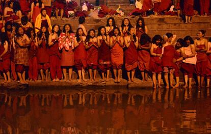 Un grupo de hindúes devotos del Nepal ofrecen sus oraciones durante un baño ceremonial en el templo Pashupatinath en el río sagrado Bagmati, durante las celebraciones del festival Swasthani, en Katmandú (Nepal).