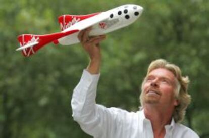 El multimillonario británico Richard Branson con un modelo a escala de su vehículo espacial.