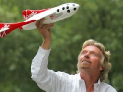 El multimillonario británico Richard Branson con un modelo a escala de su vehículo espacial.