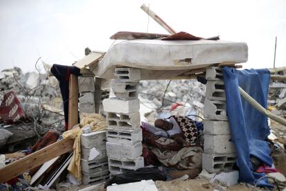 Un hombre descansa dentro de un refugio improvisado próximo a los escombros de su casa el 13 de agosto. A esa hora, todavía no se había prorrogado cinco días más la tregua, que debía acabar a las 23.00 hora española del miércoles