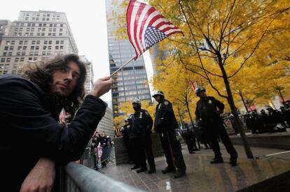 Un acampado permanece a las puertas del parque Zuccotti, en Nueva York, después de que la policía desmantelara el campamento.
