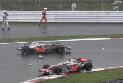 Hamilton pasa junto a Alonso (arriba), después de que éste se saliera de la pista y chocara, por lo que tuvo que abandonar el GP de Japón.