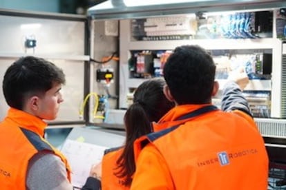 Responsables de proyecto comprueban el cuadro eléctrico de una célula robotizada.