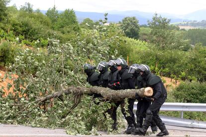 Agentes de los antidisturbios de la Guardia Civil despejan esta tarde la A-6 a la altura de Villamartín de la Abadía, en el término municipal de Carracedelo.