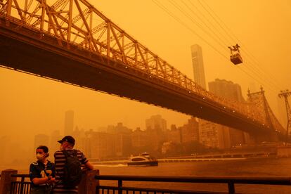 Personas usan mascarillas en el distrito de Queens (Nueva York) por el humo de los incendios en el este de Canadá que el viento ha arrastrado al sur hasta la costa este de Estados Unidos, el 7 de junio de 2023.