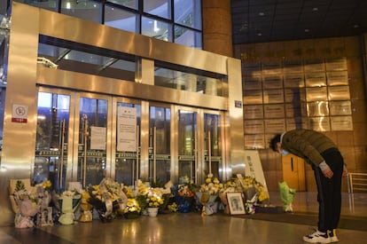 Un ciudadano deja un ramo en flores en honor al doctor Li Wenliang, en las puertas del Hospital Central de Wuhan. Las redes sociales chinas se llenaron de tributos al médico que alertó de la Covid-19. La censura china bloqueó muchos de esos homenajes al doctor de 34 años.