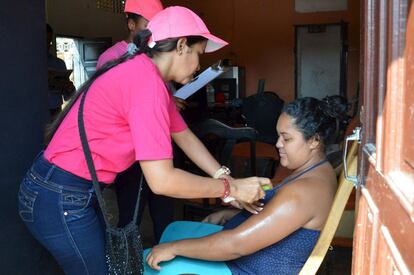 Personal sanitario ense&ntilde;a a una mujer embarazada c&oacute;mo echarse repelente contra el virus del zika en Barranquilla (Colombia)