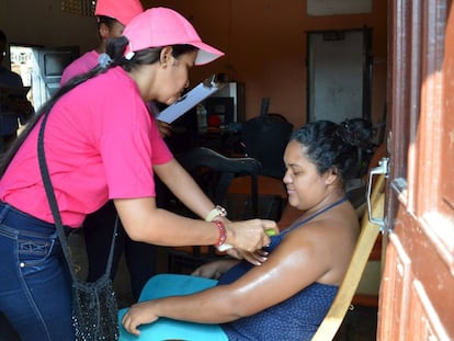 Profissionais de saúde ensinam uma mulher grávida a passar repelente contra o zika vírus em Barranquilla (Colônbia).