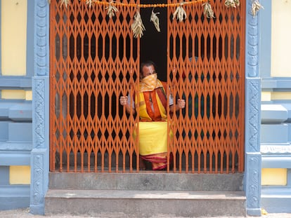 Un monje hindú mira desde el interior de un templo en India.