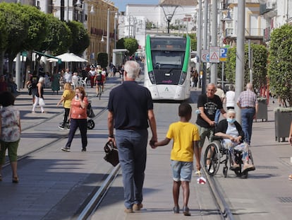 El tranvía en pruebas pasa por la Calle Real de San Fernando, Cádiz compartiendo la avenida con el tránsito de peatones y coches autorizados, aún en su fase de pruebas en blanco