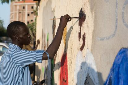 Un activista artístico pinta un muro con el permiso de su propietario en la capital de Sudán del Sur.