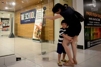 Un niño se aferra a la pierna de su madre en Kuala Lumpur (Malasia), el 30 de abril de 2016.