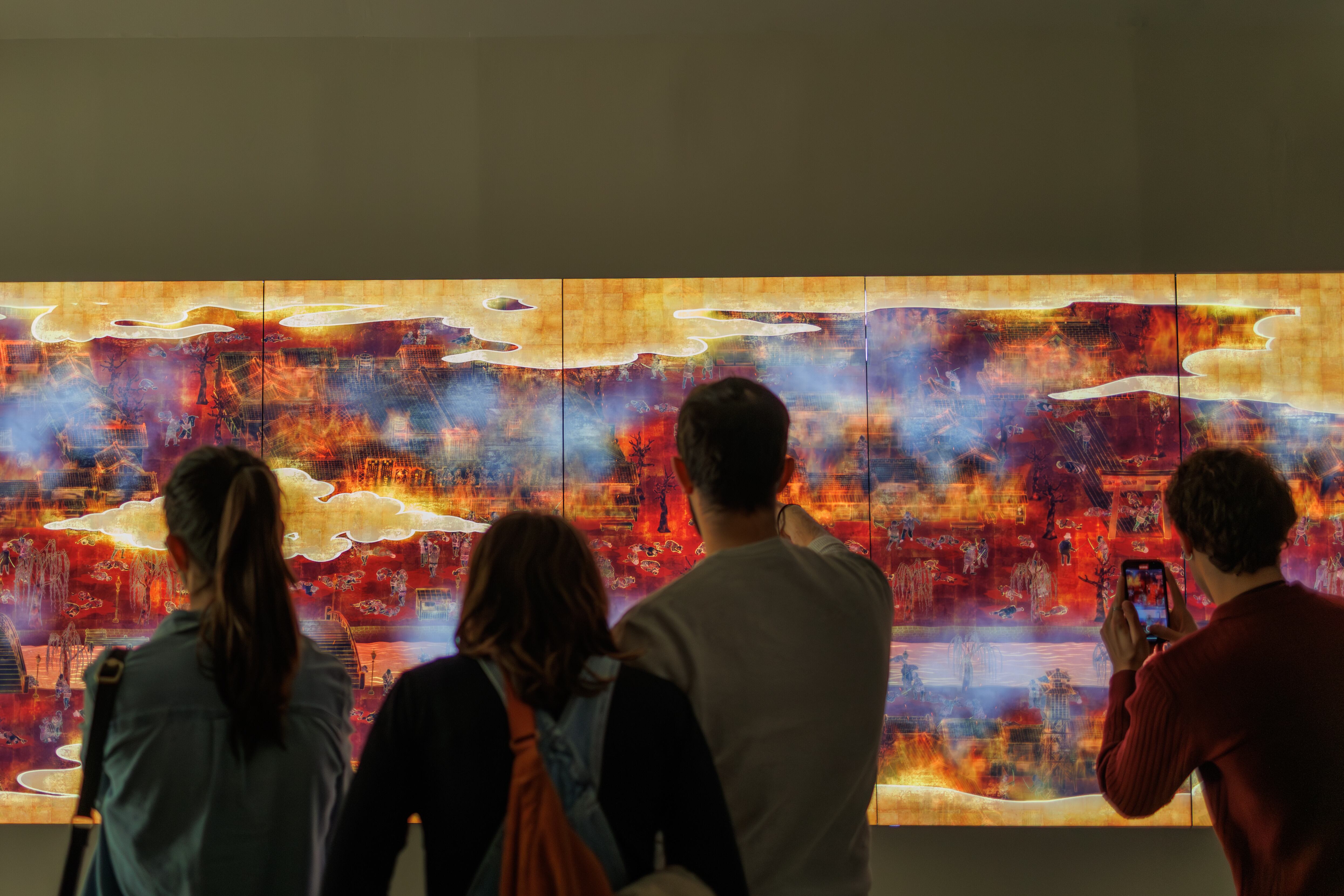 Visitantes del Centro de Arte Hortensia Herrero (Valencia) observan la obra digital 'The World of Irreversible Change' (El mundo del cambio irreversible) durante el clímax de la batalla.