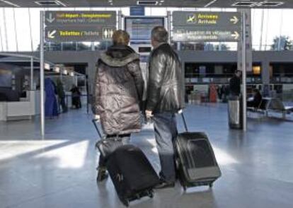 Pasajeros miran los horarios de los vuelos programados en el aeropuerto de Montpellier, Francia. EFE/Archivo