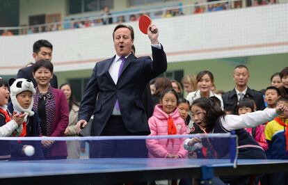 El primer ministro británico, David Cameron juega al tenis de mesa con los estudiantes de una escuela de primaria durante su viaje a Chengdu, provincia de Sichuan (China).