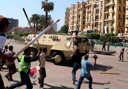 Varios manifestantes arrojan objetos a un vehículo militar en la plaza Tahrir del El Cairo.