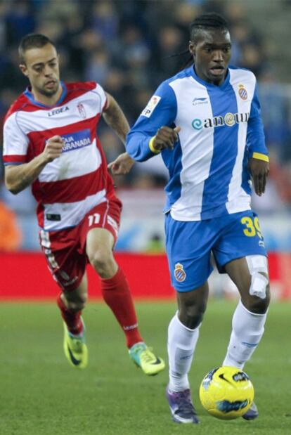 El delantero francés del RCD Espanyol Thievy Bifouma lleva el balón presionado por el centrocampista del Granada CF Dani Benítez durante el partido.