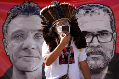 El líder indígena Kamuu Wapichana -frente a una pancarta con imágenes del periodista británico Dom Phillips, a la izquierda, y del indigenista brasileño Bruno Pereira, ambos desaparecidos en la Amazonia brasileña tras ser amenazados por pescadores furtivos- protesta por la falta de respuesta del Gobierno de Bolsonaro ante este suceso, frente al Ministerio de Justicia en Brasilia, este martes.