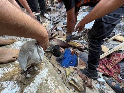 Varios palestinos intentaban rescatar a una persona de entre los escombros de un edificio derrumbado por un bombardeo israelí sobre Jan Yunis, al sur de la franja de Gaza, este lunes. 