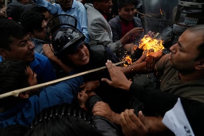 Un grupo de activistas de Nepal se enfrentan, este lunes, a la policía mientras participan en una protesta con antorchas contra el aumento de los precios de los productos derivados del petróleo, en la capital, Katmandú.
