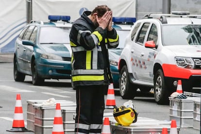 Un miembro de protección civil se tapa la cara con las manos en el exterior de la estación de metro de Maalbeek en Bruselas.