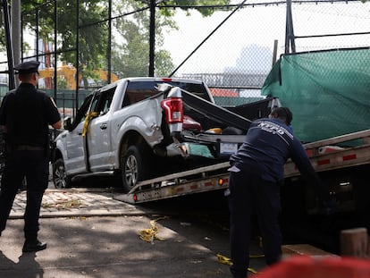 Elementos de seguridad levantan una camioneta que chocó contra una multitud que participaba en los festejos del 4 de julio en Nueva York.