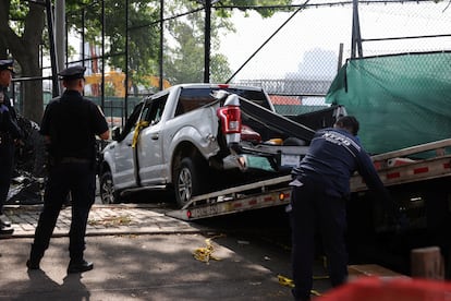 Elementos de seguridad levantan una camioneta que chocó contra una multitud que participaba en los festejos del 4 de julio en Nueva York.