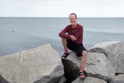 Philip Hoare, sentado junto al mar en el espigón de Bac de Roda, en Barcelona.