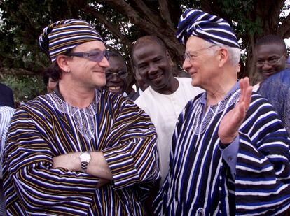 El secretario del tesoro de Estados Unidos, Paul O'Neill, y Bono vestidos con ropas tradicionales que les regalaron los habitantes de Wamali, en Tamala (Ghana). Los dos realizaron una gira conjunta por los países de África para fomentar la ayuda al desarrollo en mayo de 2002.