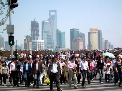 Decenas de turistas junto al río Huangpu, con el relieve de fondo del distrito financiero de Shanghái, una de las mayores ciudades chinas, el 1 de mayo de 2010.