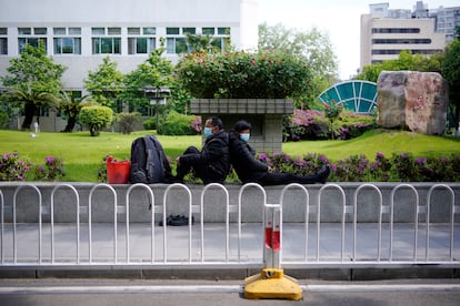 A couple wearing face masks are seen near a hospital parking lot after the lockdown was lifted in Wuhan.