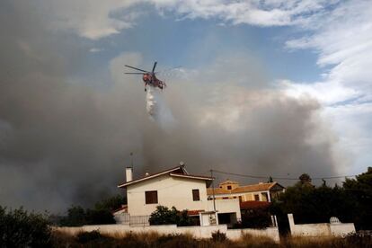Un helicòpter intenta extingir un incendi a Penteli, al nord d'Atenes.