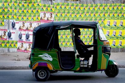 Un bajaji (tuk-tuk) espera junto a carteles electorales en Dar es Salaam, Tanzania.