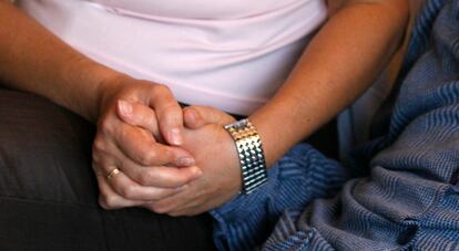 Una mujer sujeta la mano de su madre, que padece alzhéimer, en una foto de archivo.