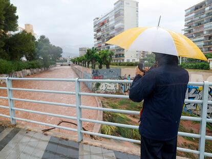 Una persona toma imágenes del caudal en un barranco en Benicàssim (Castellón), donde se han alcanzado los 220 litros por metro cuadrado de precipitación acumulada.