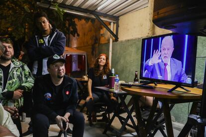 Un grupo de personas se reúne alrededor del televisor para ver la entrevista de Lula, el expresidente y de nuevo candidato presidencial, en el programa de la red Globo, 'Jornal Nacional', este jueves.