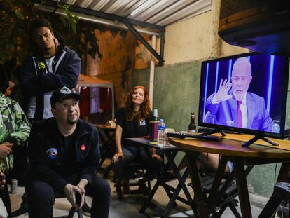 Un grupo de personas se reúne alrededor del televisor para ver la entrevista de Lula, el expresidente y de nuevo candidato presidencial, en el programa de la red Globo, 'Jornal Nacional', este jueves.