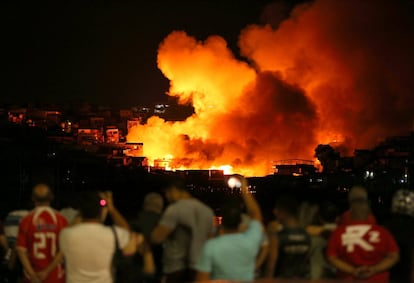 Moradores do bairro Educando, em Manaus, assistem às chamas que queimam na favela do Bodozal.